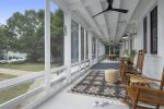 Beautiful front screen porch with rocking chairs and outdoor dining